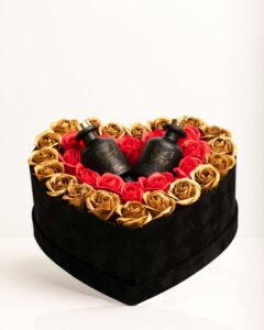 heart shaped box with gold and red roses on top